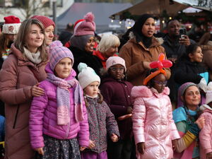 Blick ins Publikum. Frauen und Kinder erfreuen sich am Programm. Ein schwarzer Mann film mit seinem Handy.