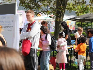 Im Freien. Sonne scheint. Fest mit Ständen und Kindern.
