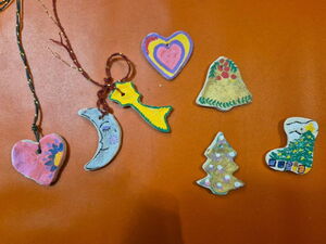 Weihnachtliche Ton-Anhänger. Zwei Herzen, ein Mond, eine Sternschnuppe, Glöckchen, alle hübsch bemalt.