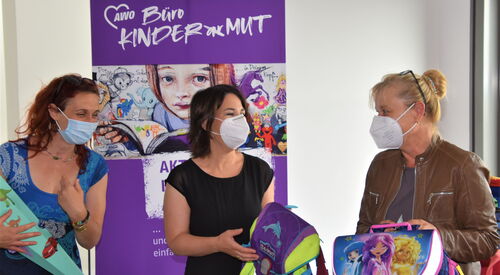 3 Personen vor dem Plakat des Büro Kindermutes