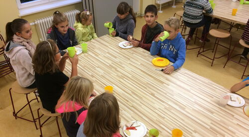 9 Kinder am Frühstückstisch beim Essen.