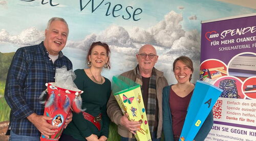 Gruppenbild: 2 Männer und 2 Frauen, drei davon halten Zuckertüten in der Hand. Alle lächeln in die Kamera.