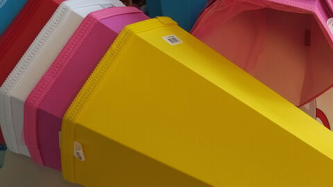 Bastelmaterial und bunte Schultüten-Rohlinge auf einem Tisch.