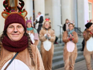 5 Frauen in Rentier-Kostümen stehen vor einer Treppe und lächeln breit in die Kamera.