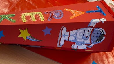 Eine rote Schultüte mit Astronauten und dem Namen Tarek in glitzer-bunten Buchstaben.