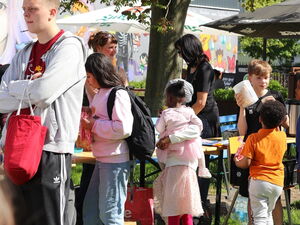 Im Freien. Sonne scheint. Fest mit Ständen und Kindern.