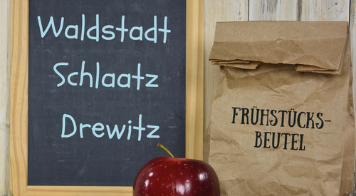 Schild, Apfel und Frühstücksbeutel