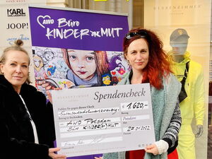 Zwei Frauen halten einen Spendencheck hoch
