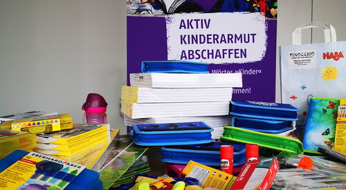 Ein Plakat vom Büro Kindermut mit Schreibwaren im Vordergrund