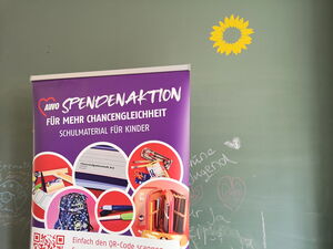 Lila Roll-Up Spendenaktion für mehr Chancengleichheit - Schulmaterial für Kinder.