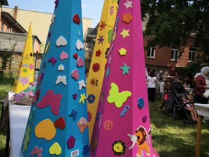Farbige, bunt beklebte Zuckertüten stehen auf einem Tisch draußen.