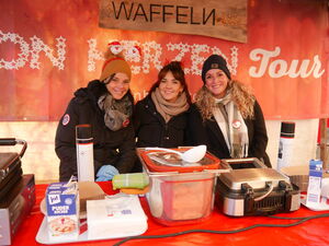 Drei Frauen im Waffelstand. Sie lächeln in die Kamera.