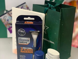 Inhalt einer dunkelgrünen Spendentüten für Jungen, Rasierklingen, After-Shave-Balsam, Deo