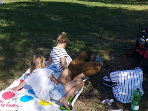 Kinder spielen Twister in einem Park.