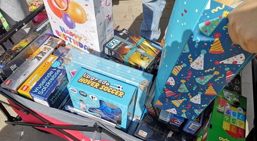 Ein Bollerwagen beladen mit Spielen und Geschenktüten.
