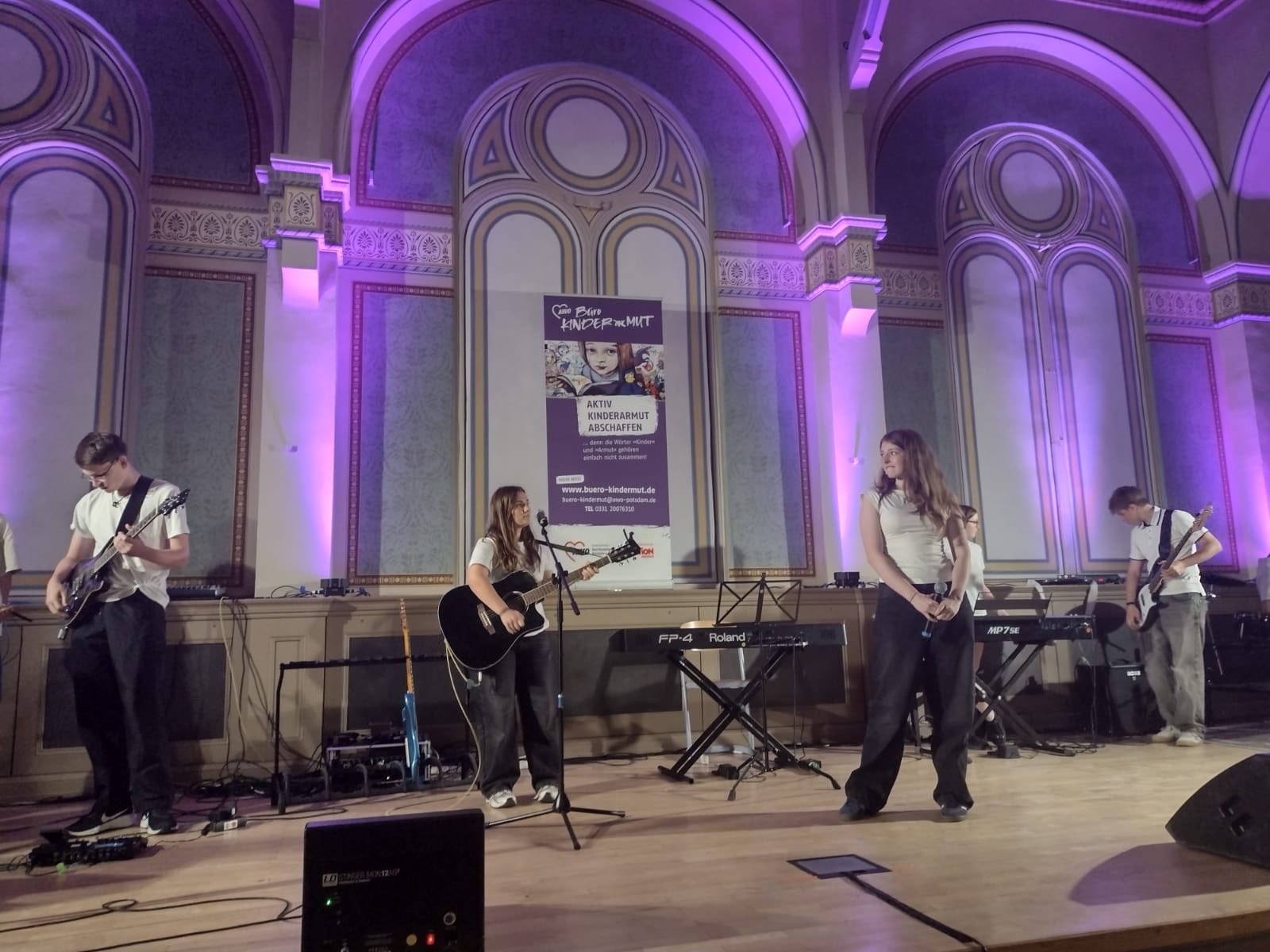 Junge Band. Gitarre, Bass Keyboard, Sängerin. Gemischt, Mädchen und Jungen auf der Bühne.