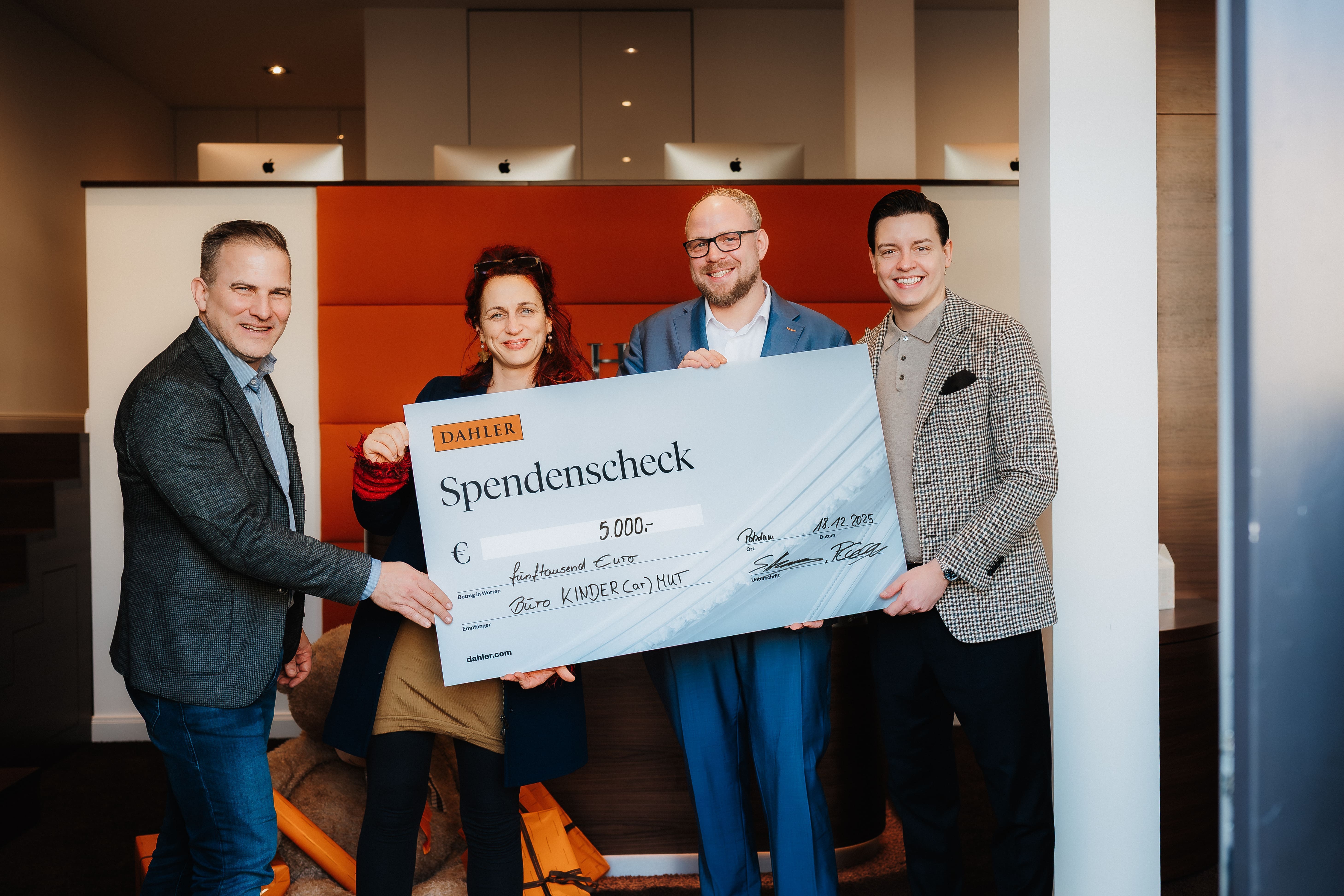 Stefan Hamann und Phillip Carstens von Dahler und Company übergeben einen symbolischen Spendenscheck über 5000 Euro an Franziska Löffler und Jörn Mensching, Leitung des AWO Büro Kindermut