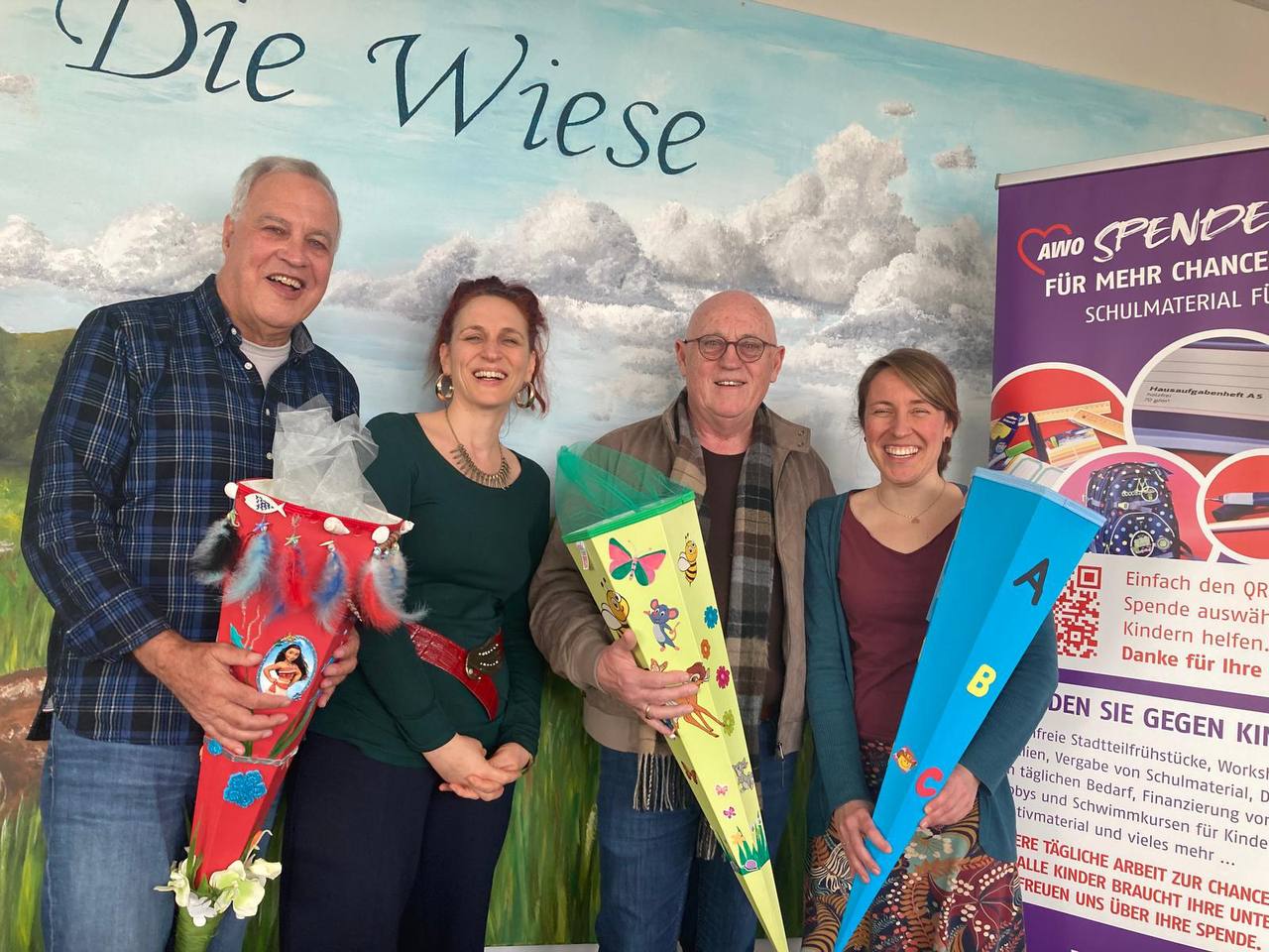 Gruppenbild: 2 Männer und 2 Frauen, drei davon halten Zuckertüten in der Hand. Alle lächeln in die Kamera.